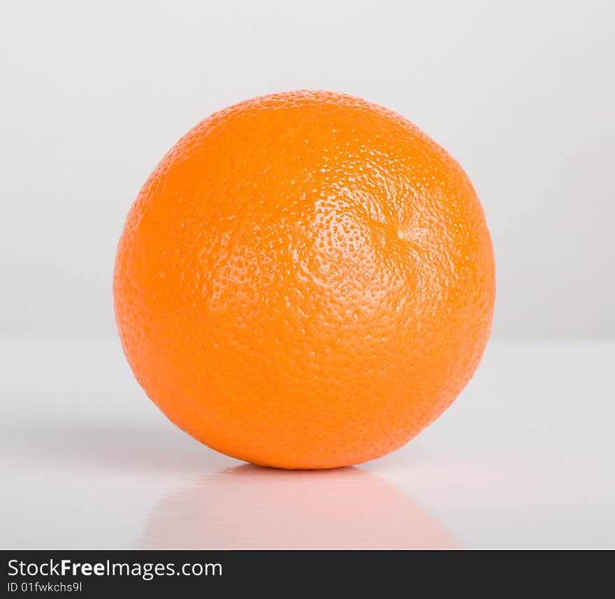 Orange on table with reflection, shot in studio