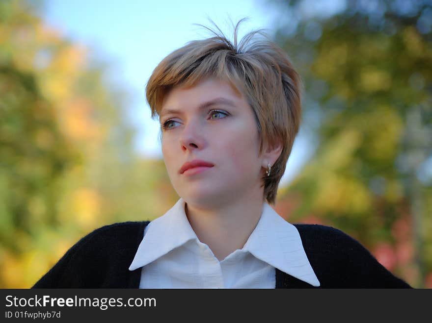 Young woman in a park on a background a green grass on a lawn