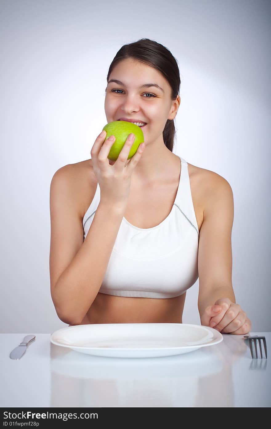 Happy woman eating a green apple smiling. Happy woman eating a green apple smiling