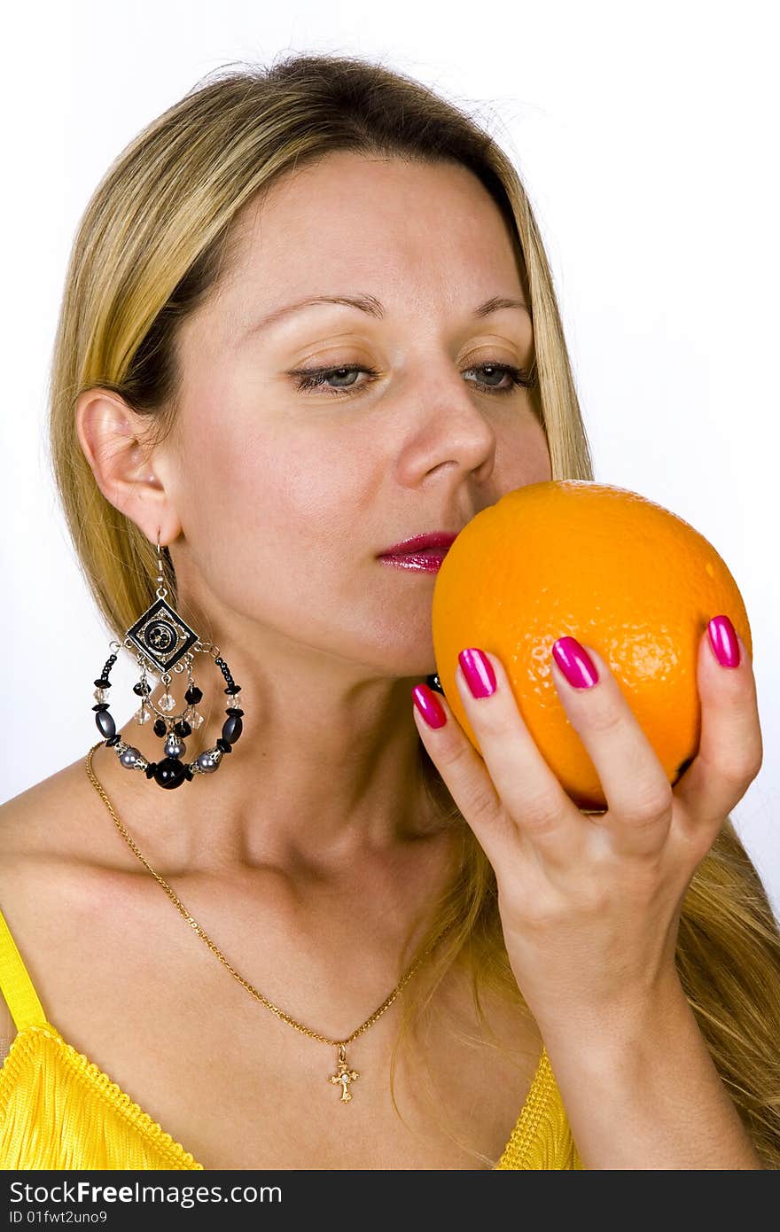 Blonde woman in yellow dress with  orange in her hand