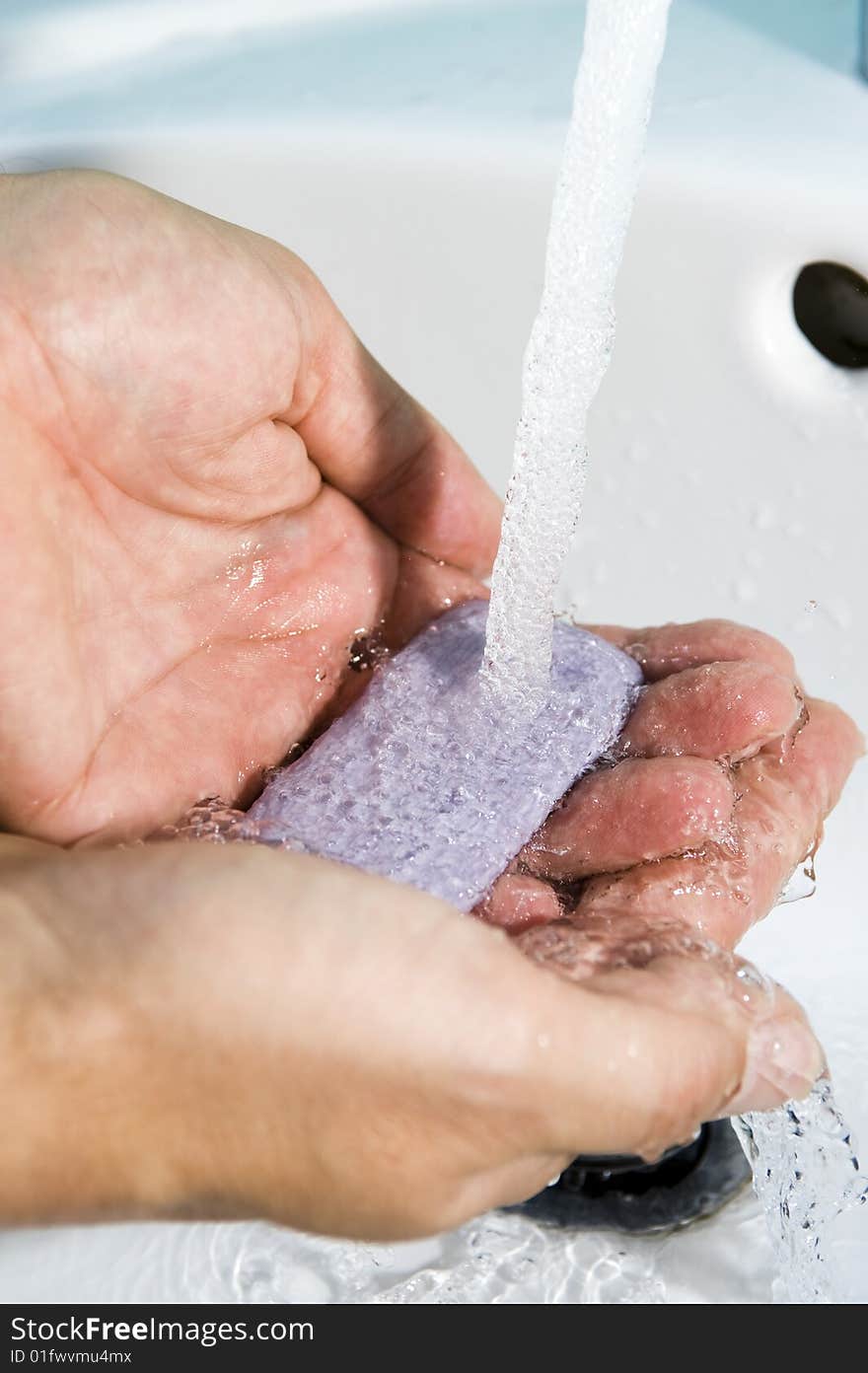 Hands of a person being washed under a tap. Hygiene is important. Hands of a person being washed under a tap. Hygiene is important.