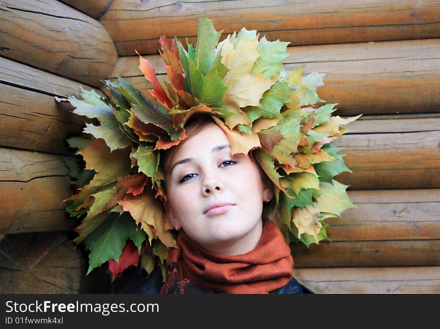 Girl with autumn yellow  leaves at the wood background