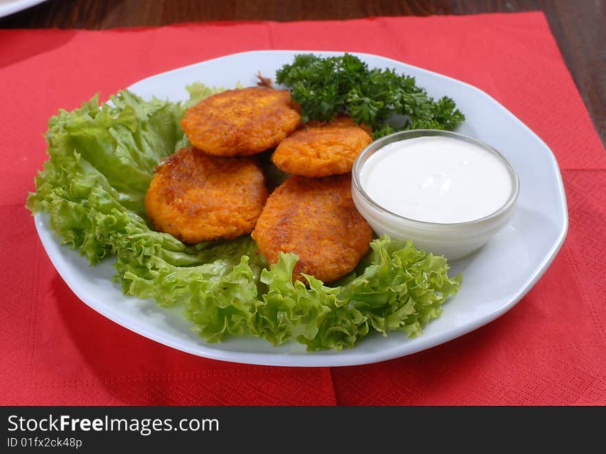 A plate of tastychops decorated with green salad and served with sauce. A plate of tastychops decorated with green salad and served with sauce