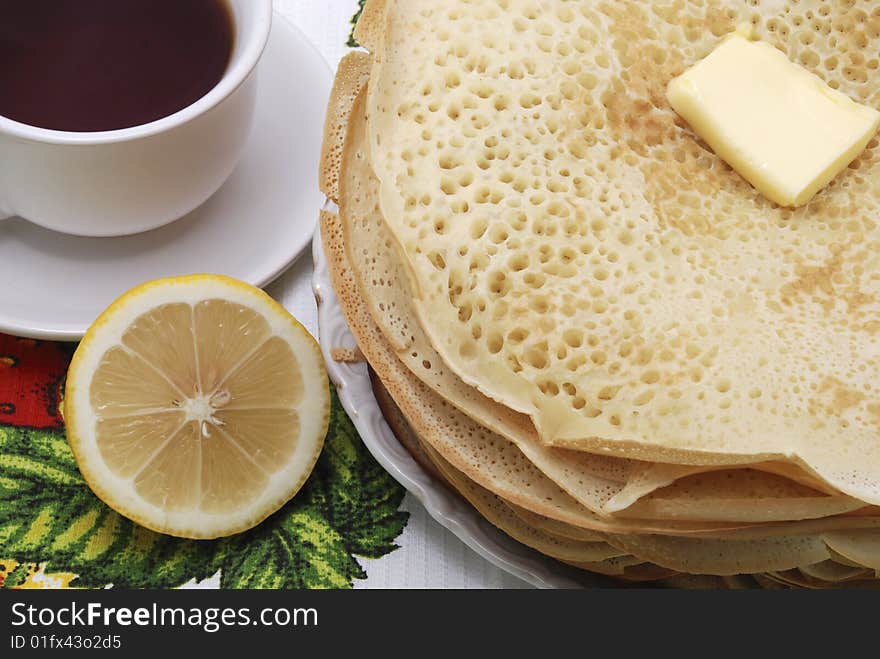 Pile fresh pancake with butter and tea. Pile fresh pancake with butter and tea