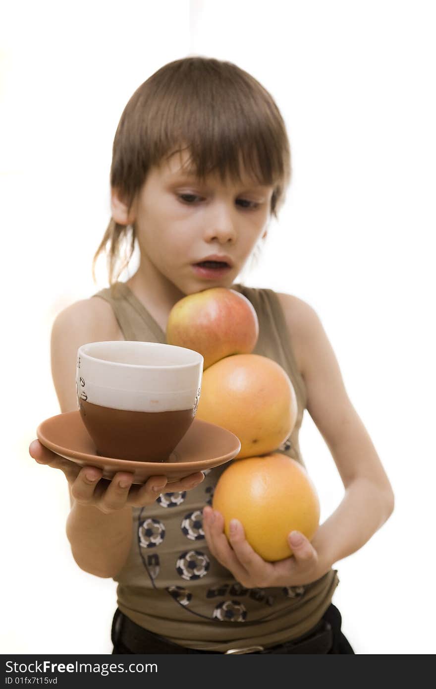 Young boy hold an apple and two grapefruits and cup of coffee. Young boy hold an apple and two grapefruits and cup of coffee