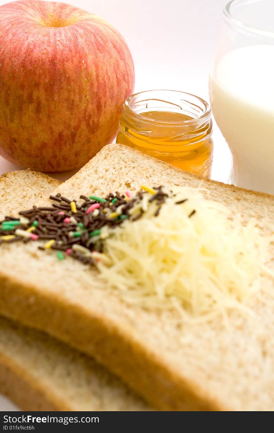 Meal ingredient for healthy & easy breakfast: wheat bread, fruit jam, chocolate sprinkles, a glass of milk and apple. Meal ingredient for healthy & easy breakfast: wheat bread, fruit jam, chocolate sprinkles, a glass of milk and apple