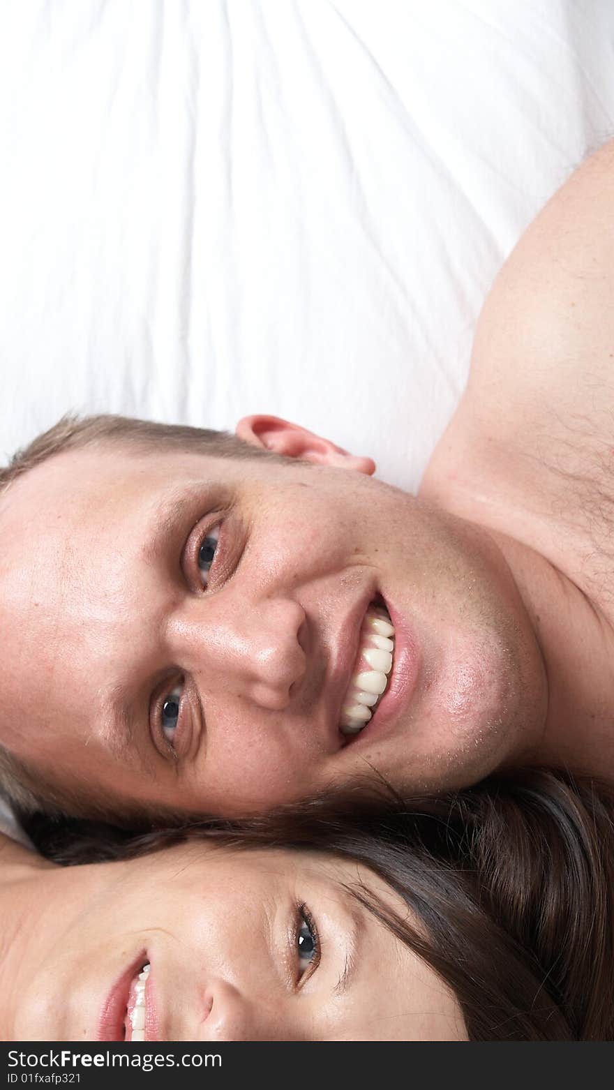 Portrait of young happy loving couple in their bedroom. Portrait of young happy loving couple in their bedroom.