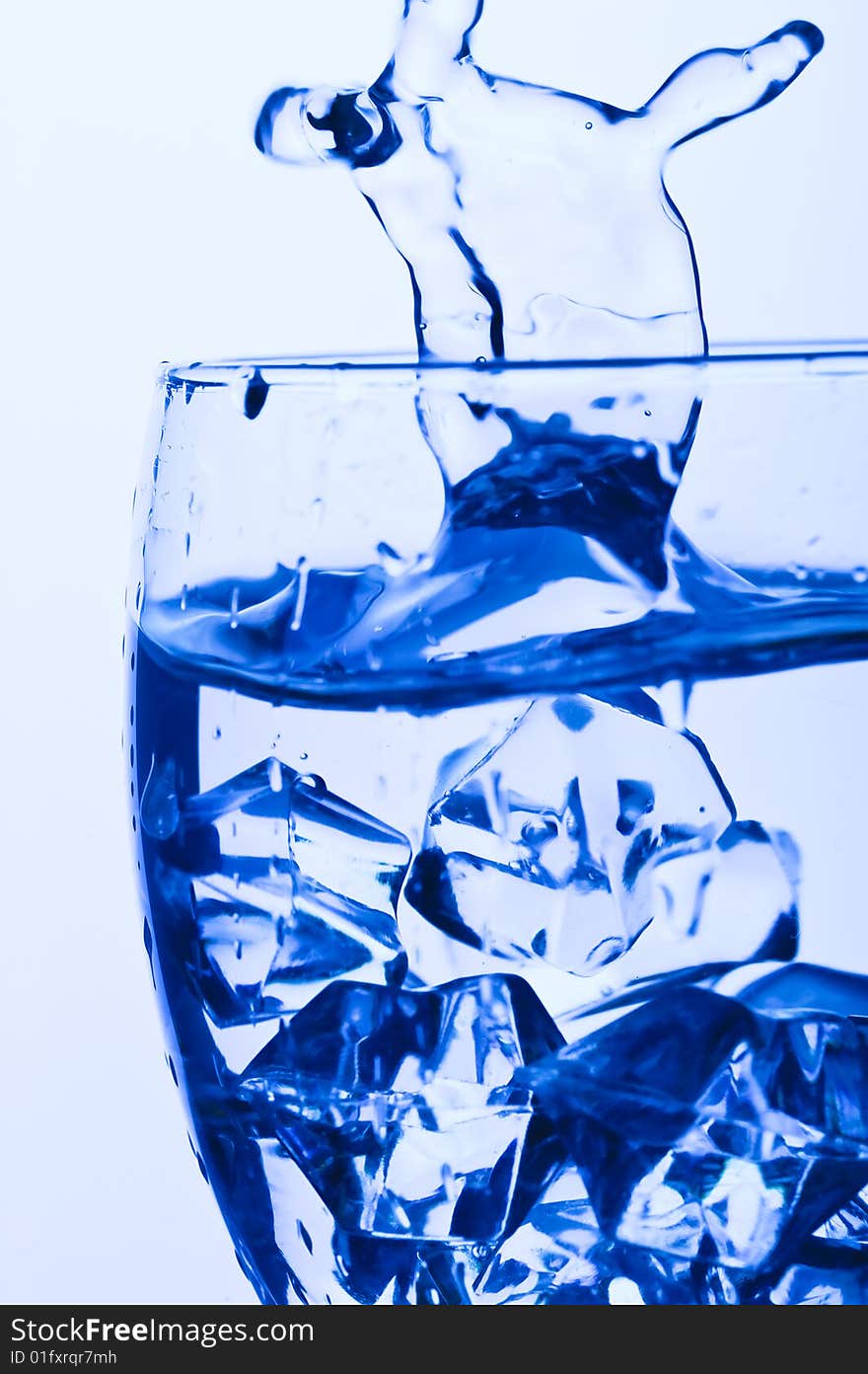 Blue Glass with Splashing water. Coolness Drink