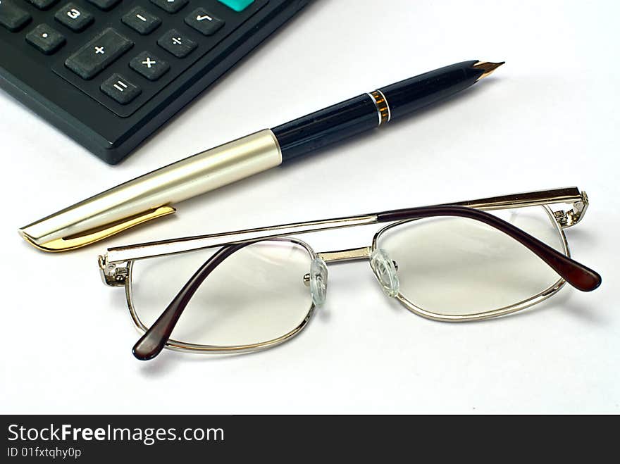 Calculator, pen and spectacles