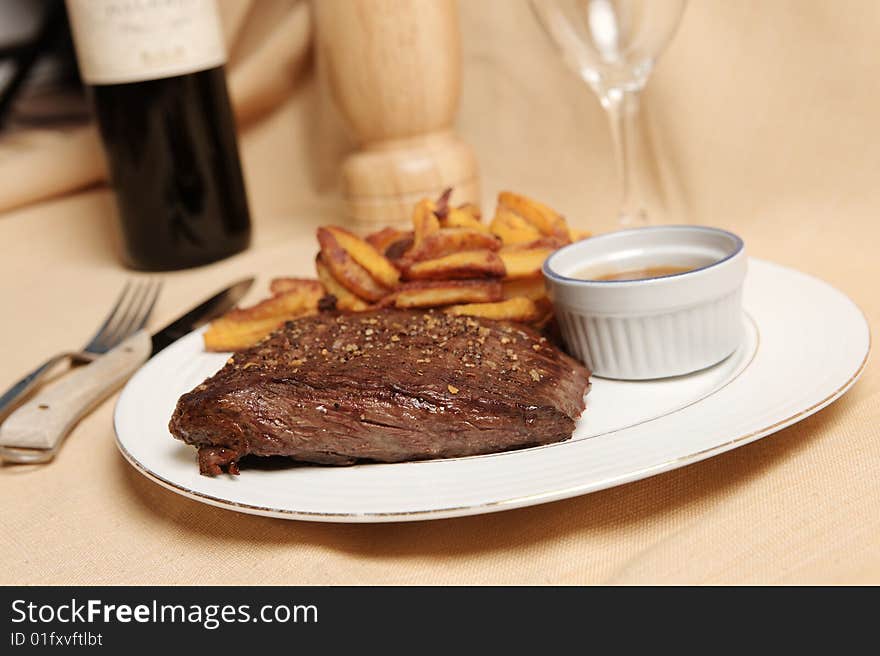 Steak and frite on a plate with focus on the steak. Steak and frite on a plate with focus on the steak