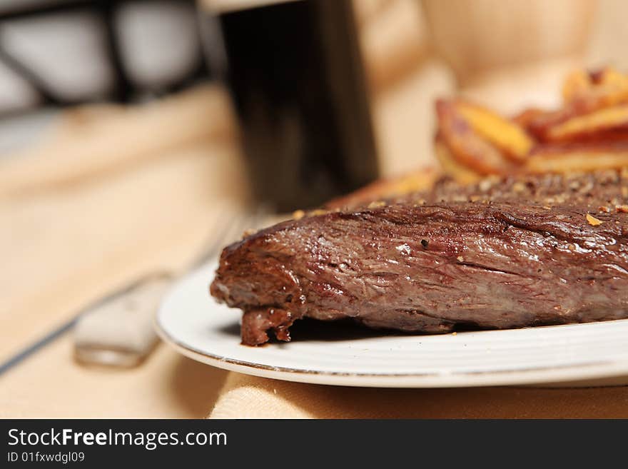 Steak and frite on a plate with focus on the steak. Steak and frite on a plate with focus on the steak