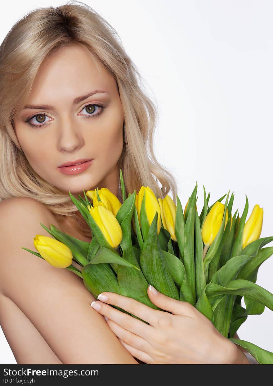 Portrait of the girl on a white background with yellow flowers tulips