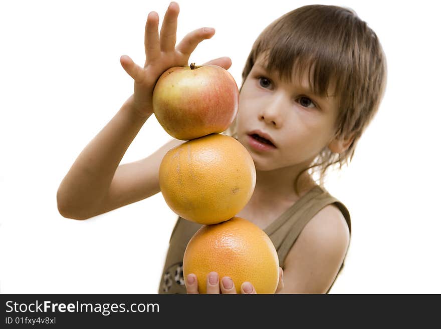 Young boy hold an apple and two grapefruits. Young boy hold an apple and two grapefruits