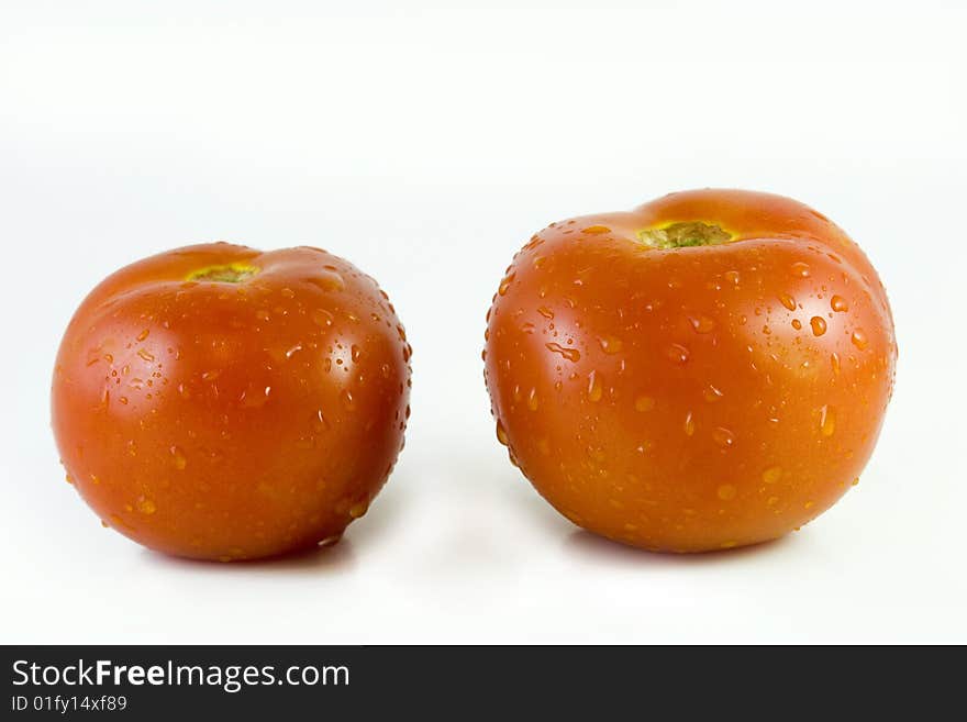 Two fresh tomatoes in water droplets