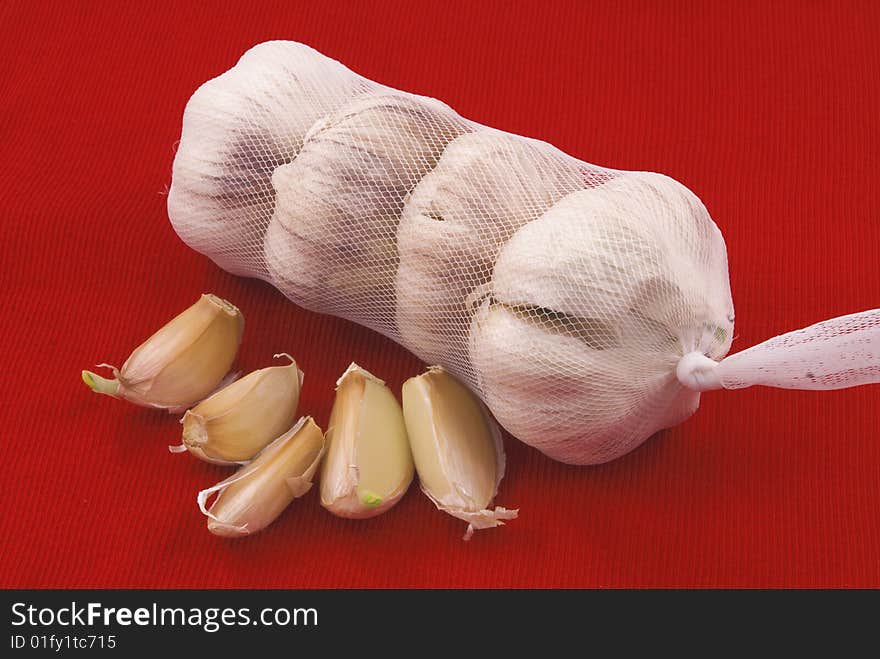 Garlic in the package with the slices on a red background