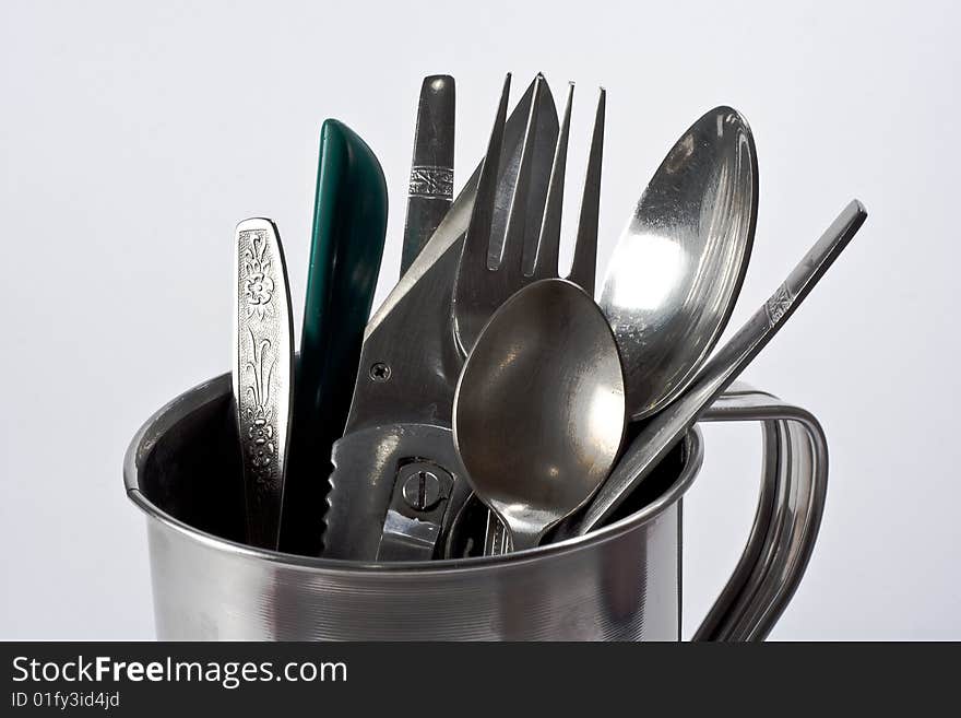 Cutlery in a silver mug.