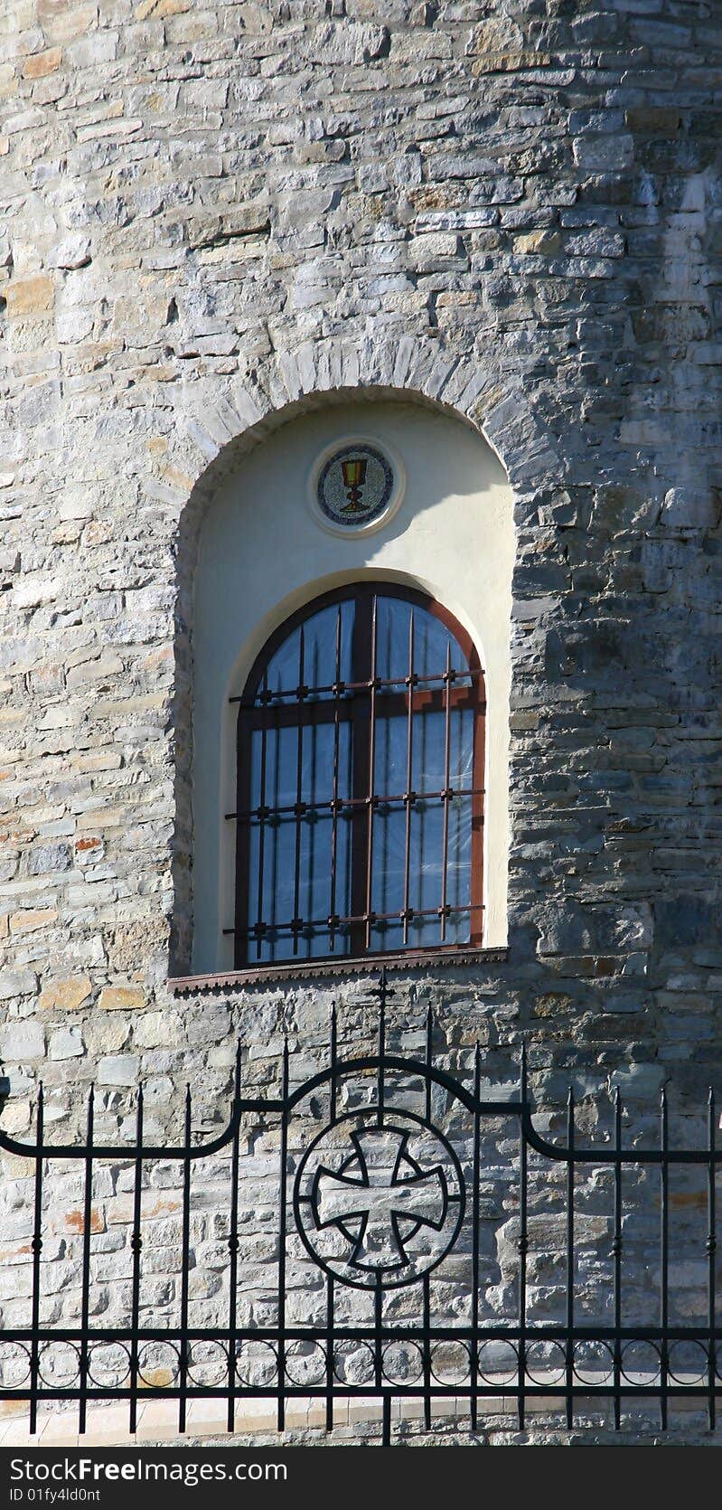 Window with a lattice in a stone wall of church