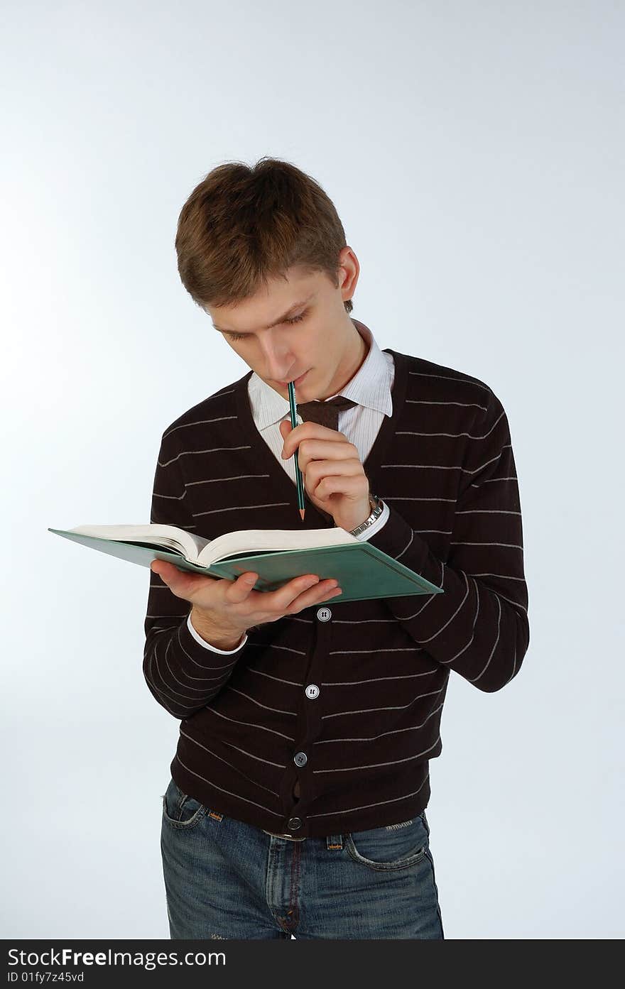 Young man reading a book and making some notes. Young man reading a book and making some notes