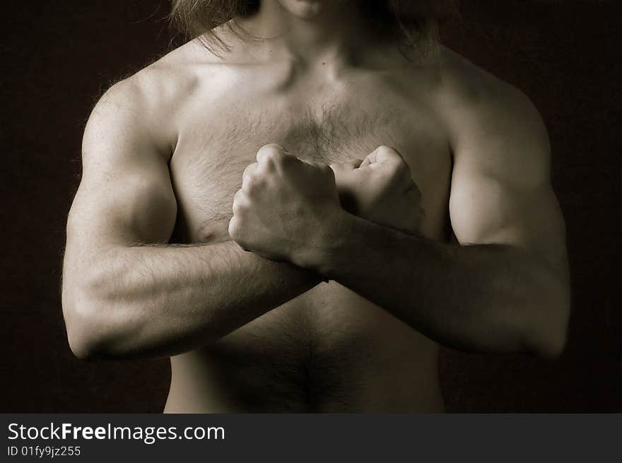 Muscular male torso with crossed arms in a sign of 'X'