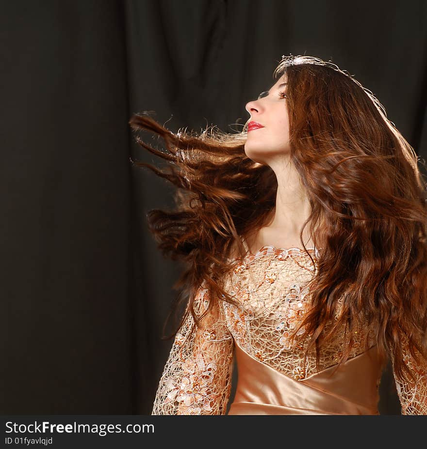 Portrait of beautiful woman with hair flying on black background