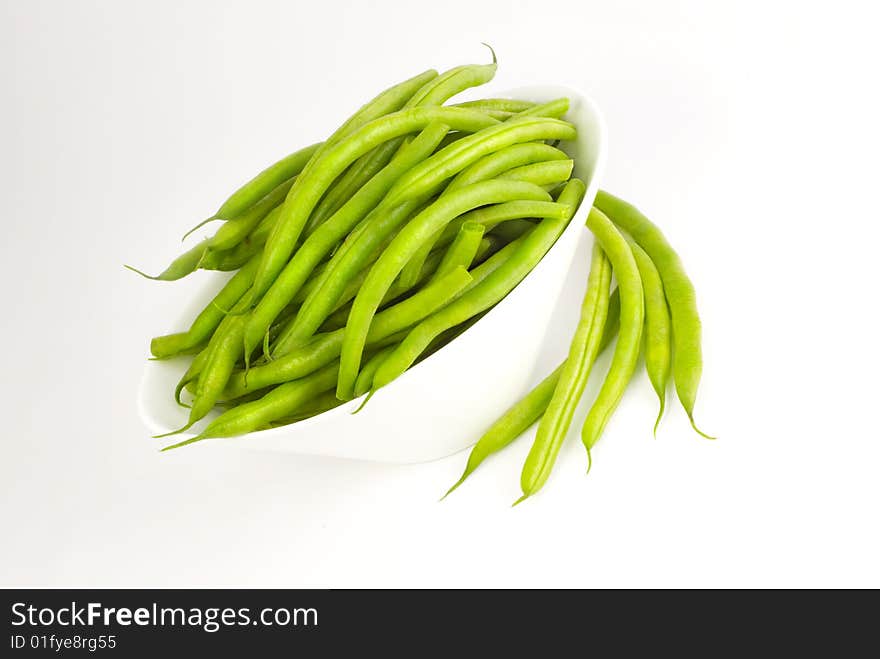 Fresh whole green beans in a white bowl isolated with copy space. Fresh whole green beans in a white bowl isolated with copy space