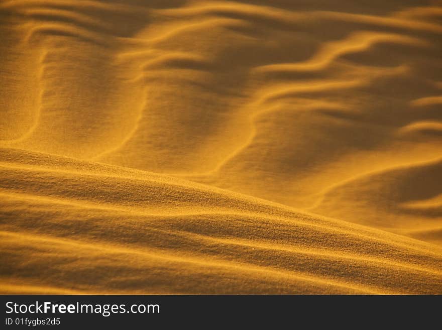 Desert sand pattern glows in evening sun. Desert sand pattern glows in evening sun