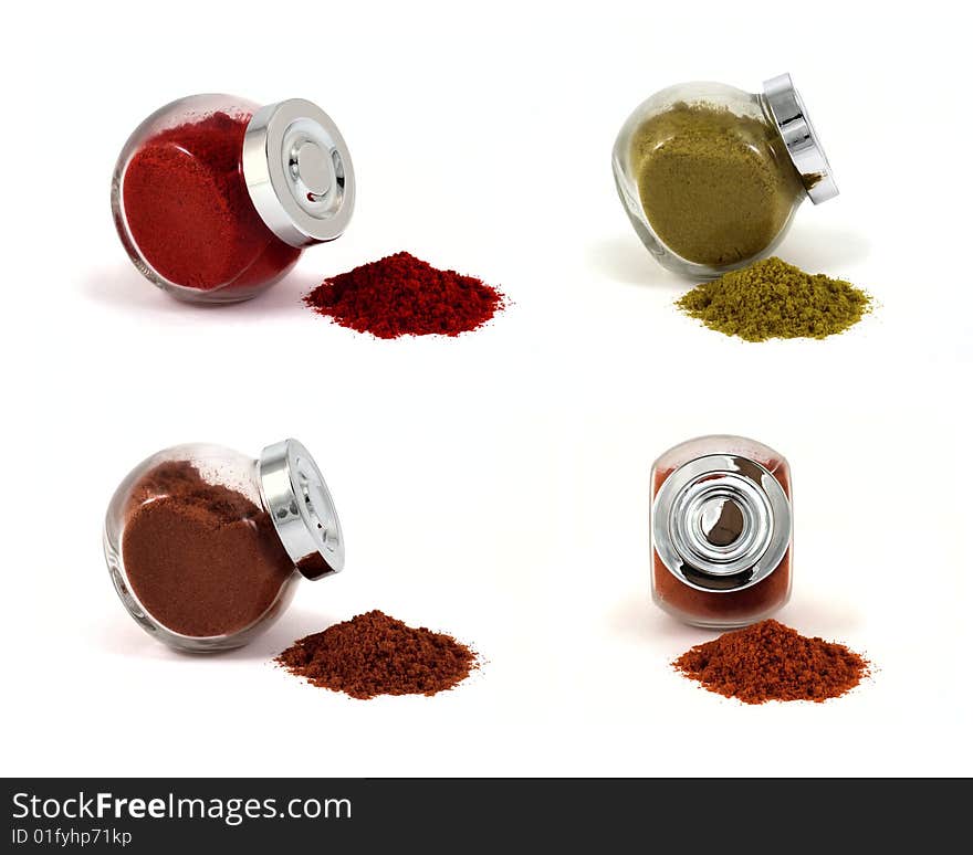 Four jars with spices on isolated white background, focus at jars caps