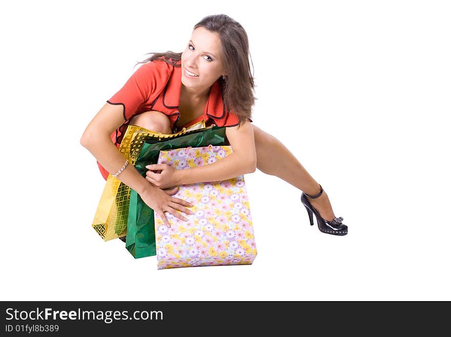 The young beautiful girl with purchases in colour packages during shopping on a white background. The young beautiful girl with purchases in colour packages during shopping on a white background