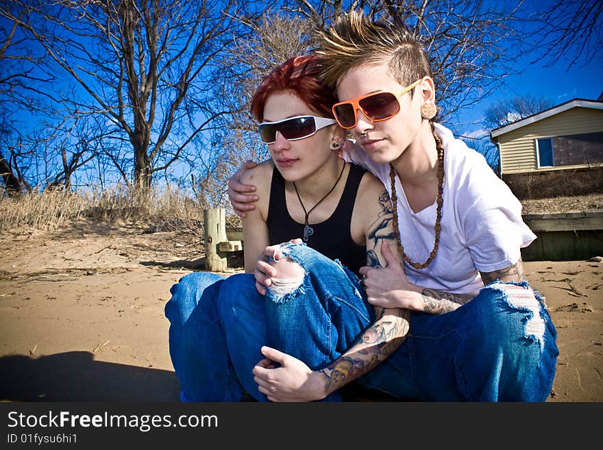 Two young women crouching on the beach