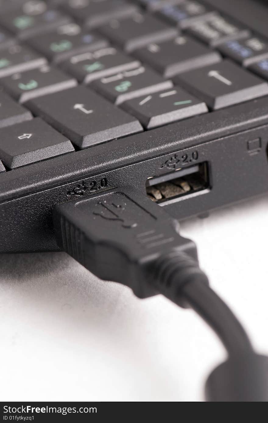 USB cable plugged into a laptop computer. USB cable plugged into a laptop computer