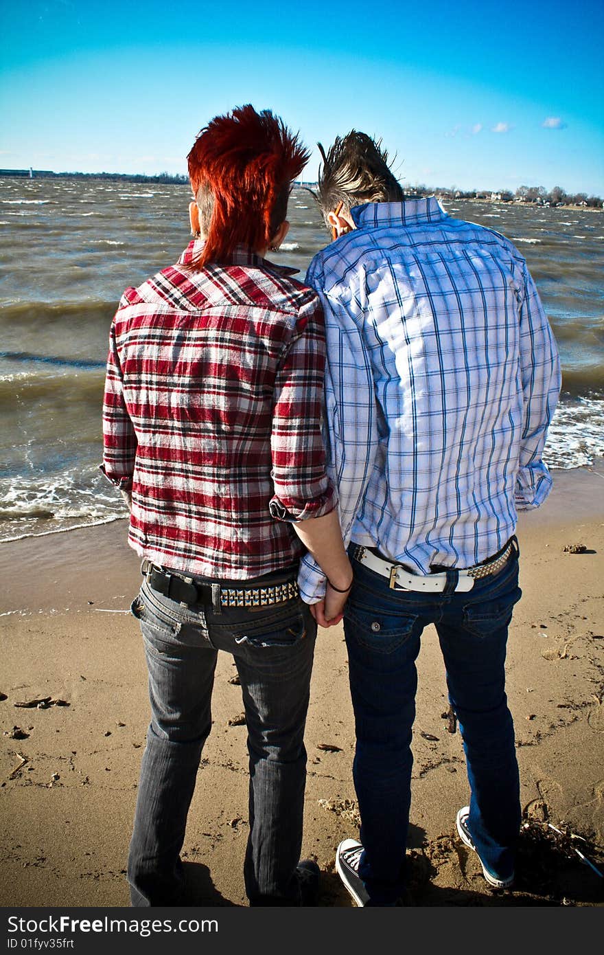 Two young women standing on the beach and holding hands