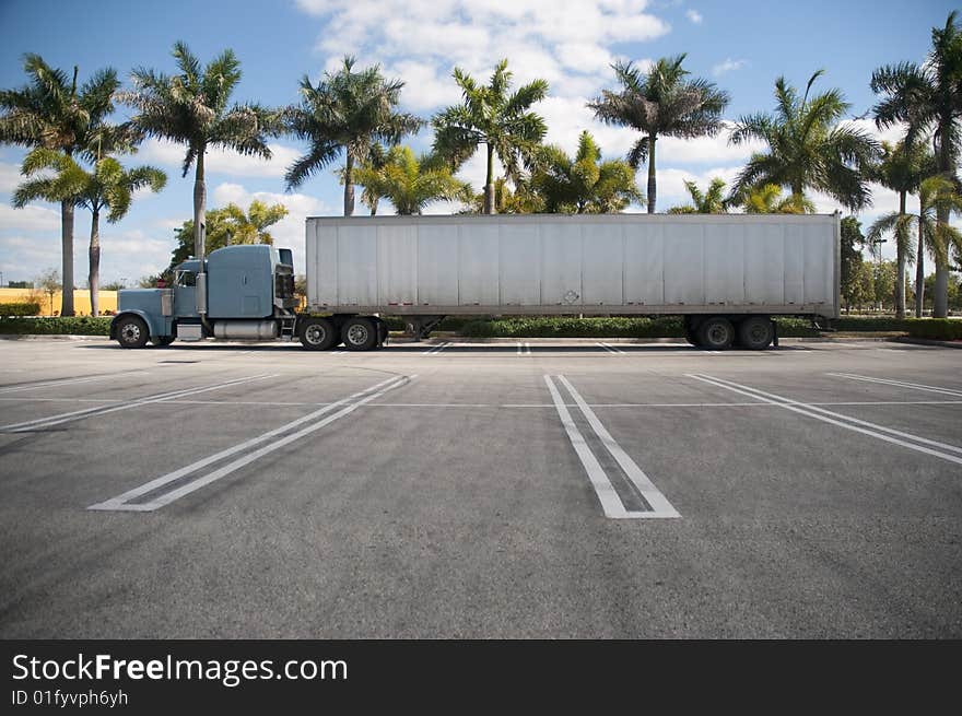 Parked Semi with tropical background and an empty parking lot