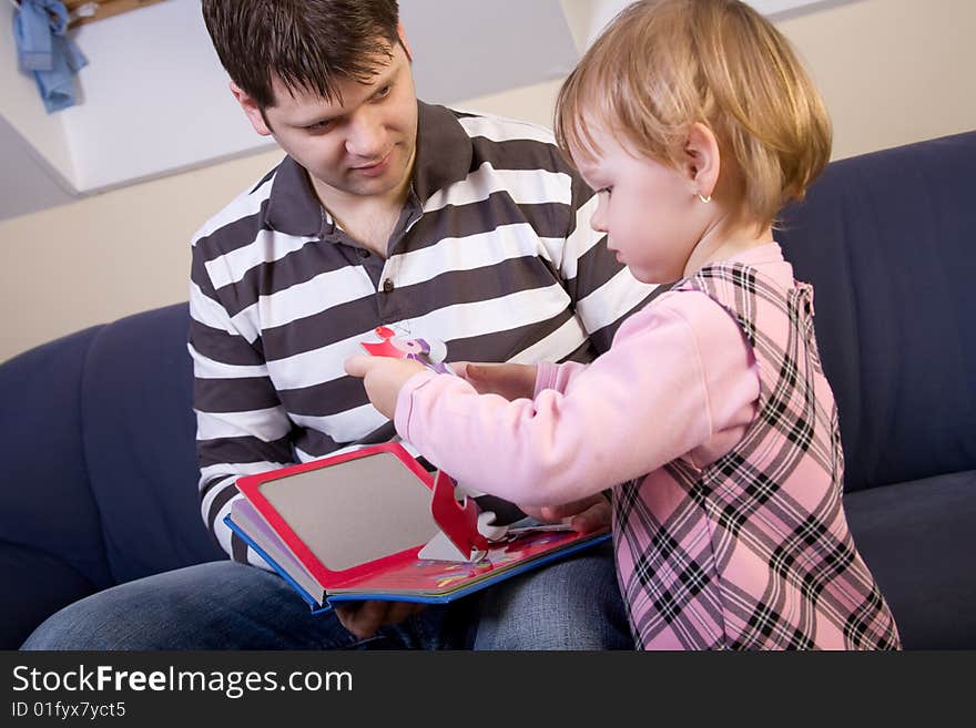 Little girl play with father with puzzle