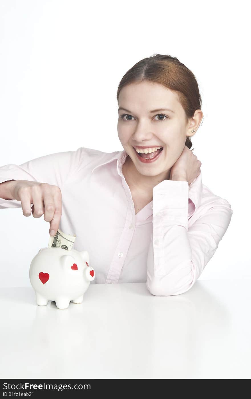 Pretty young women putting money in piggybank. Pretty young women putting money in piggybank