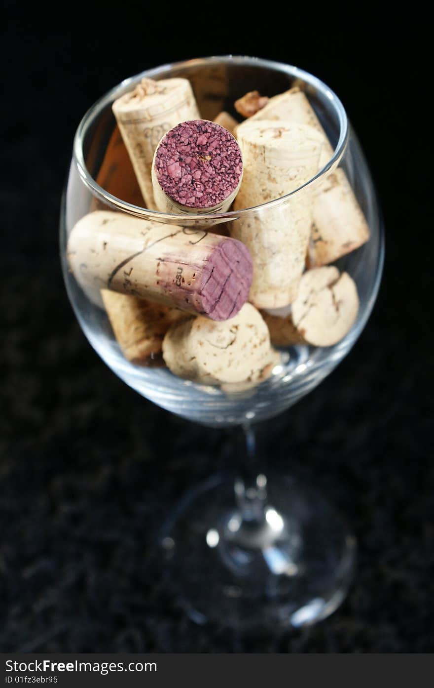 Wine corks displayed in a wine glass on a black backdrop. Wine corks displayed in a wine glass on a black backdrop