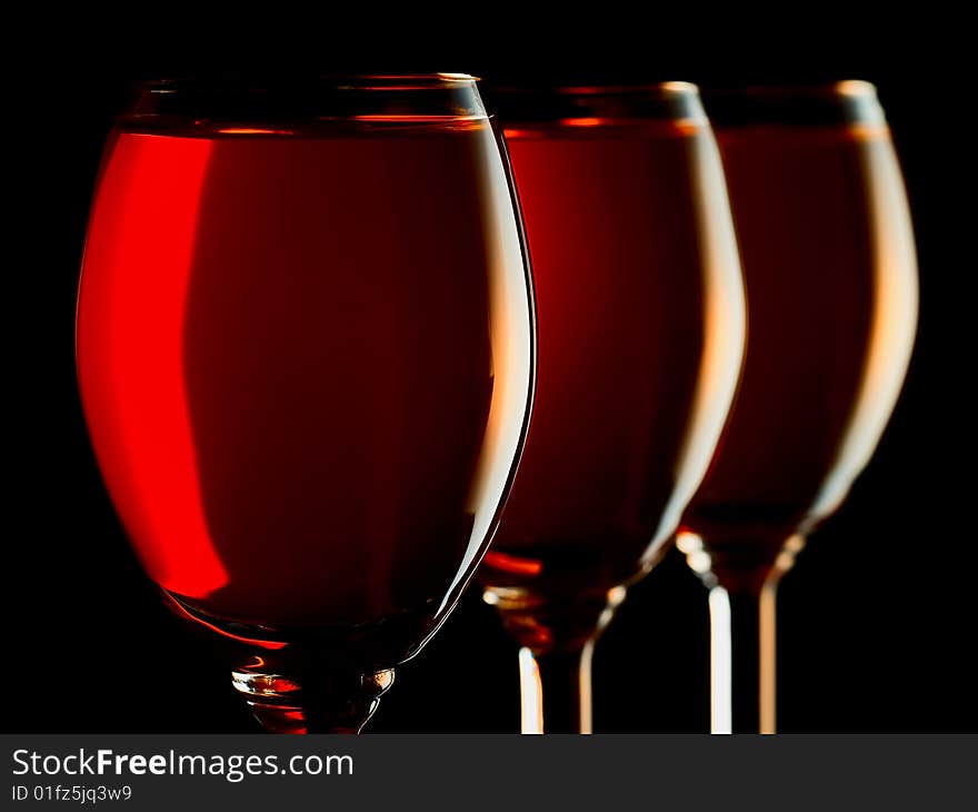 Three small glasses filled with colorful liquor on black background. Three small glasses filled with colorful liquor on black background