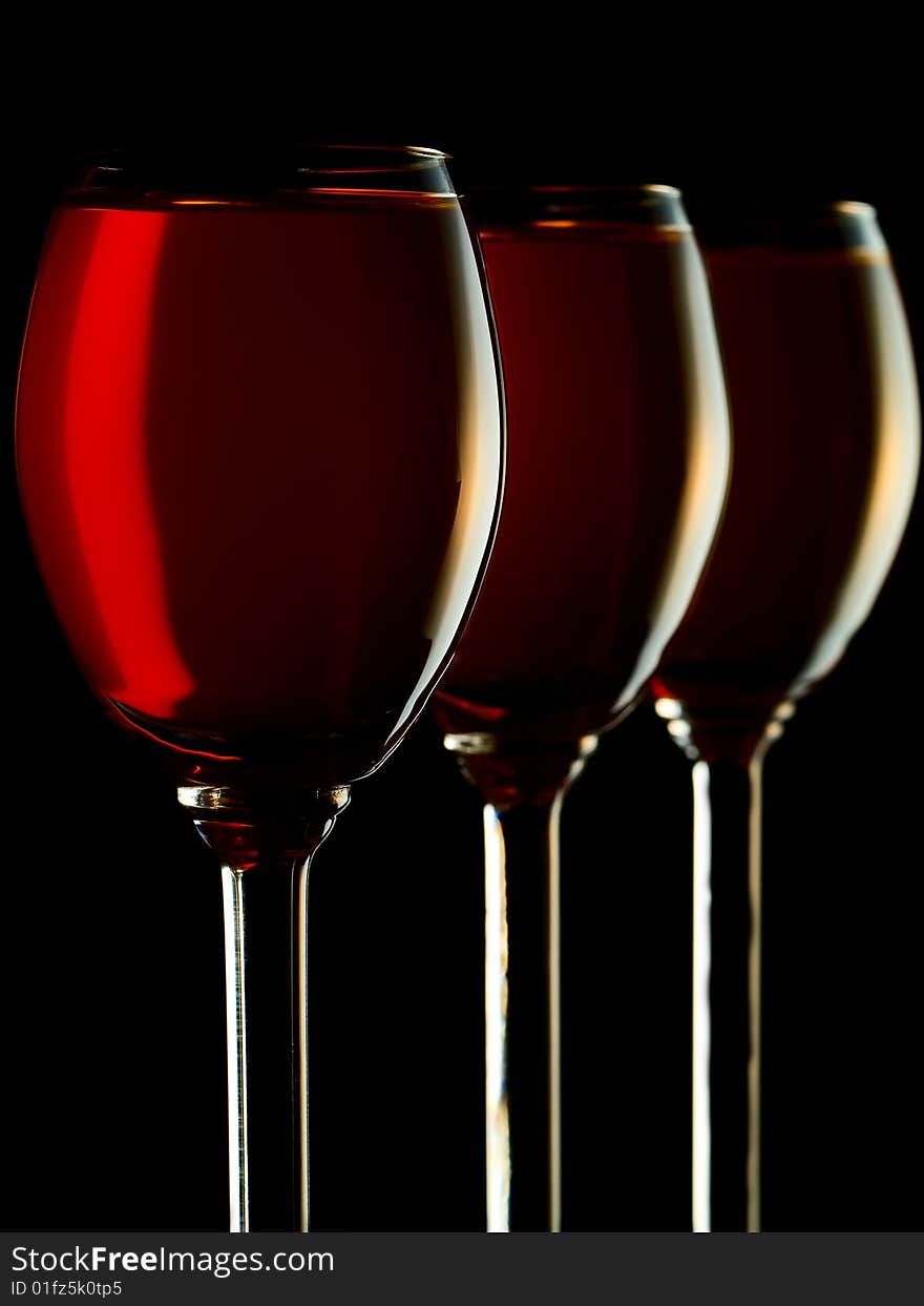 Three small glasses filled with colorful liquor on black background. Three small glasses filled with colorful liquor on black background