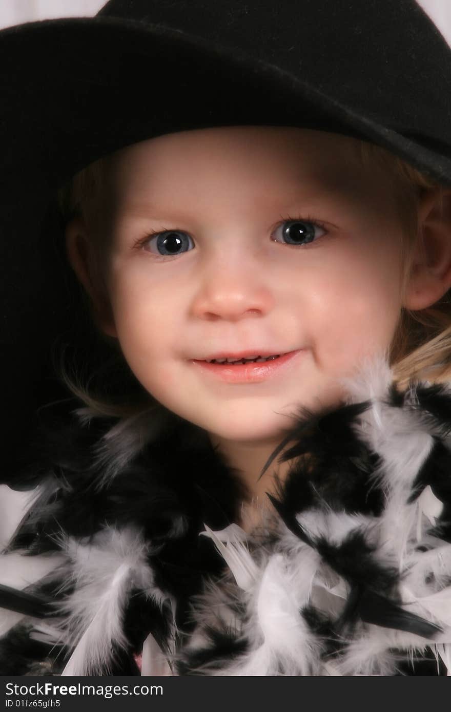 Young girl with black hat and black and white feather boa. Young girl with black hat and black and white feather boa