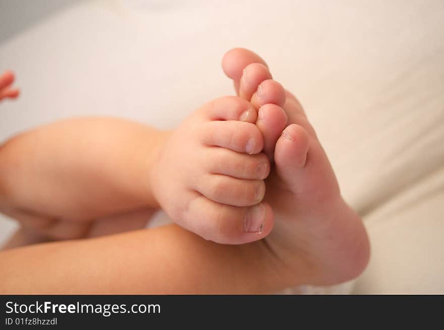 Cute baby feet on blanket background, with toes curled around, and feet touching. Cute baby feet on blanket background, with toes curled around, and feet touching.