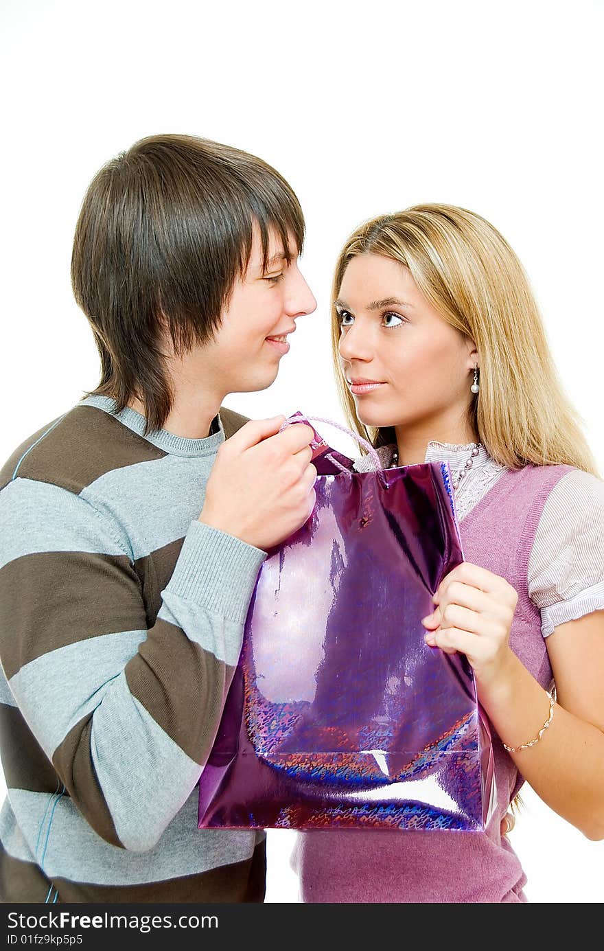 Young couple in incomprehension with gift packet on white. Young couple in incomprehension with gift packet on white