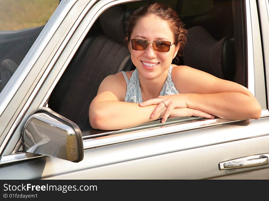 Woman smile through opened car window. Woman smile through opened car window