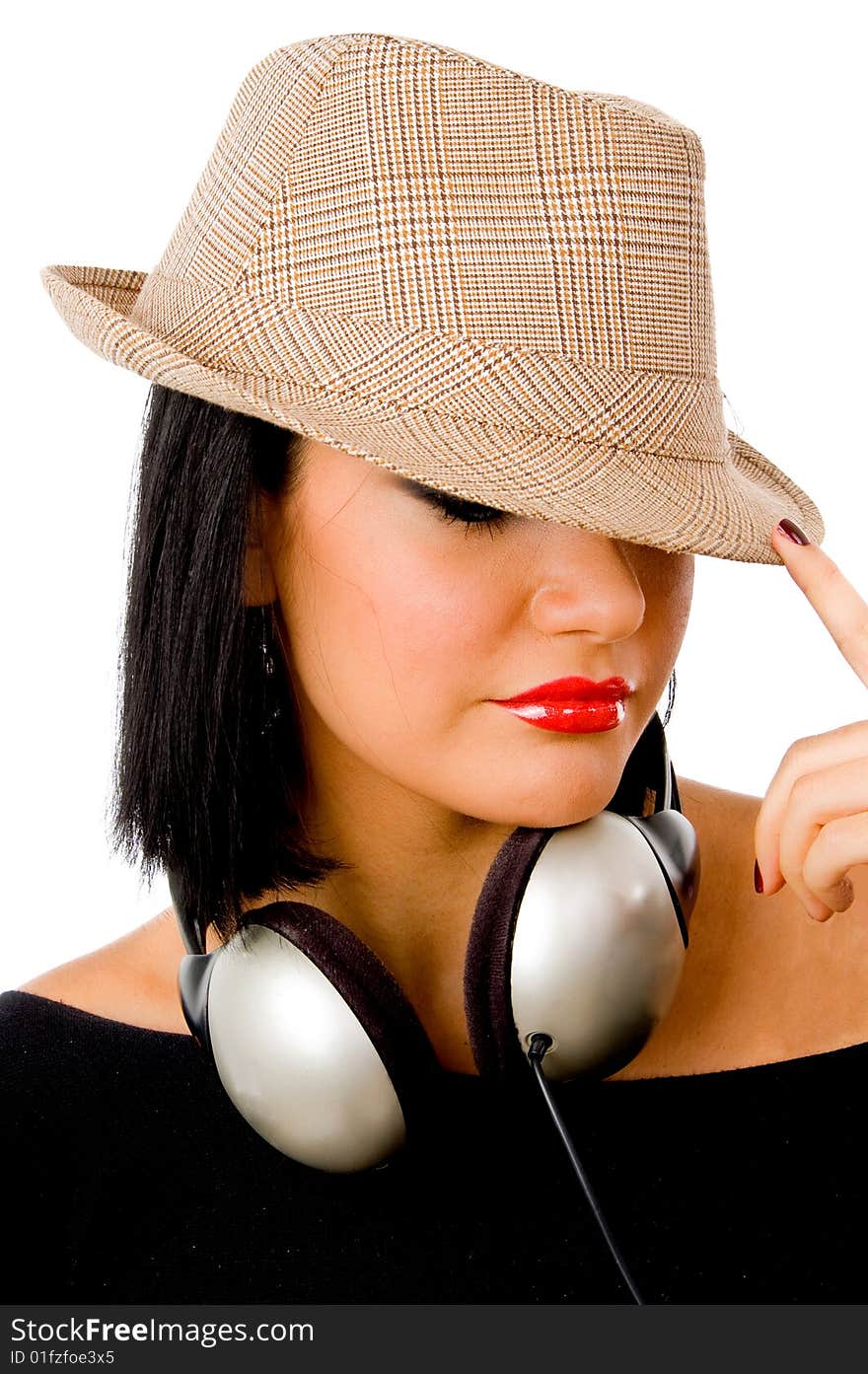 Portrait of young female wearing headphone and hat against white background