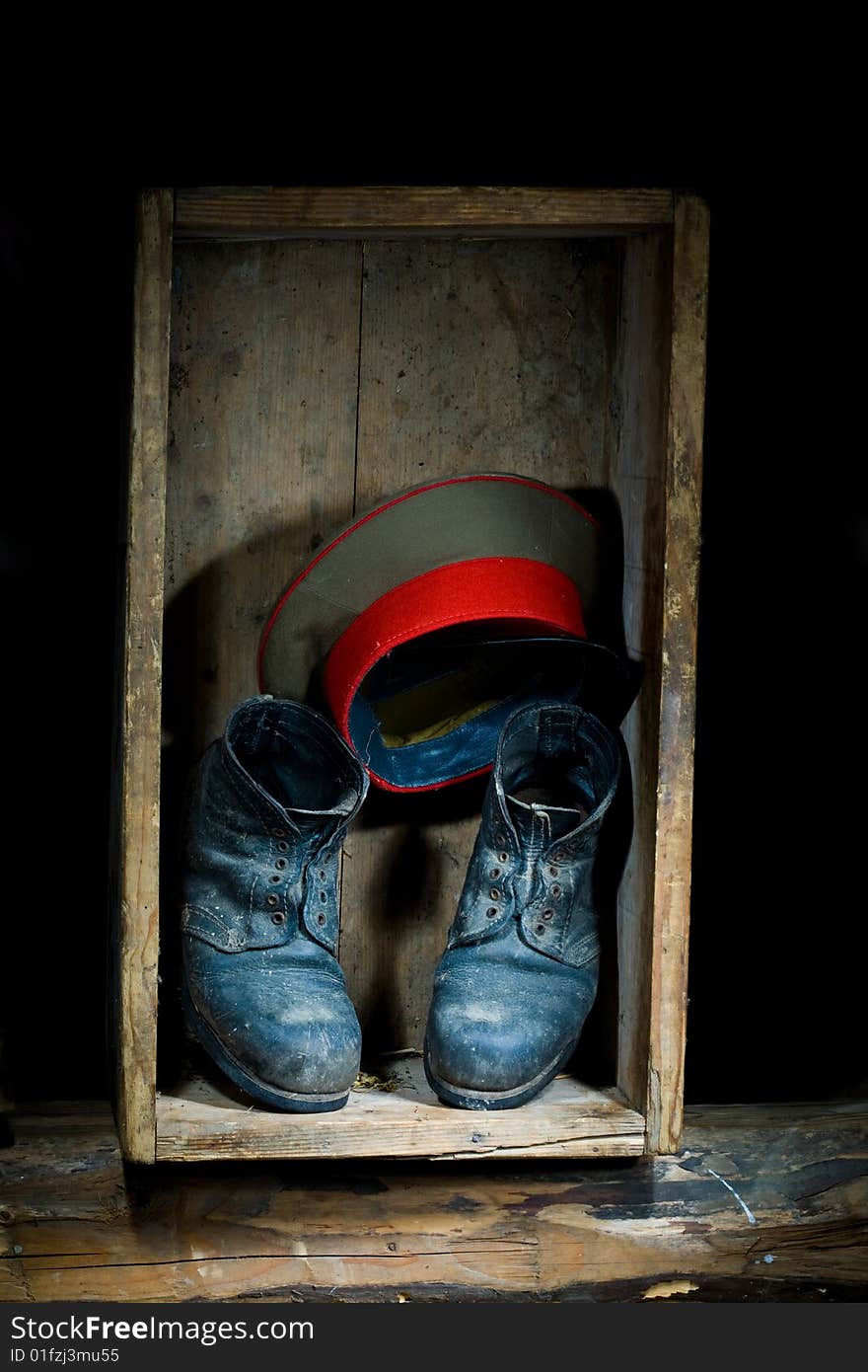 Stock photo: an image of old boots and a hat in a box. Stock photo: an image of old boots and a hat in a box