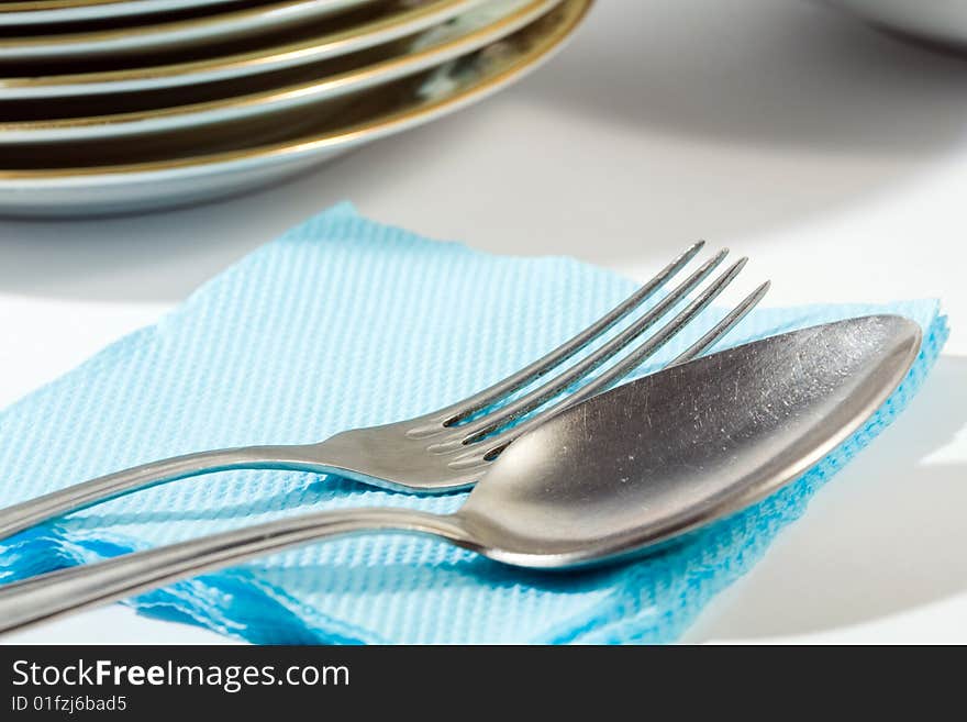 Stock photo: an image of a spoon and a fork on blue napkin. Stock photo: an image of a spoon and a fork on blue napkin