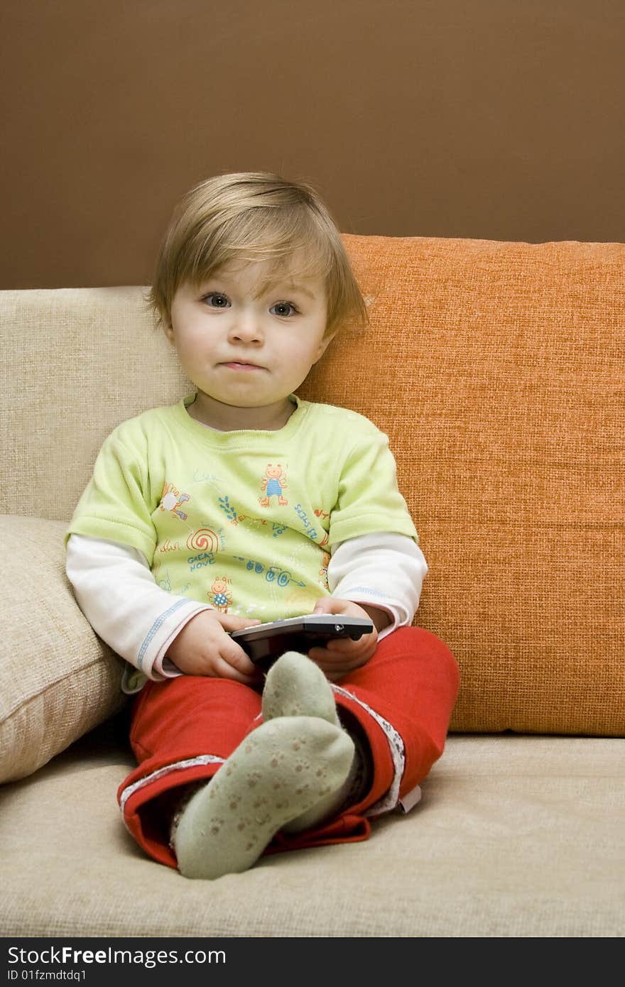 Baby girl with remote control on  sofa