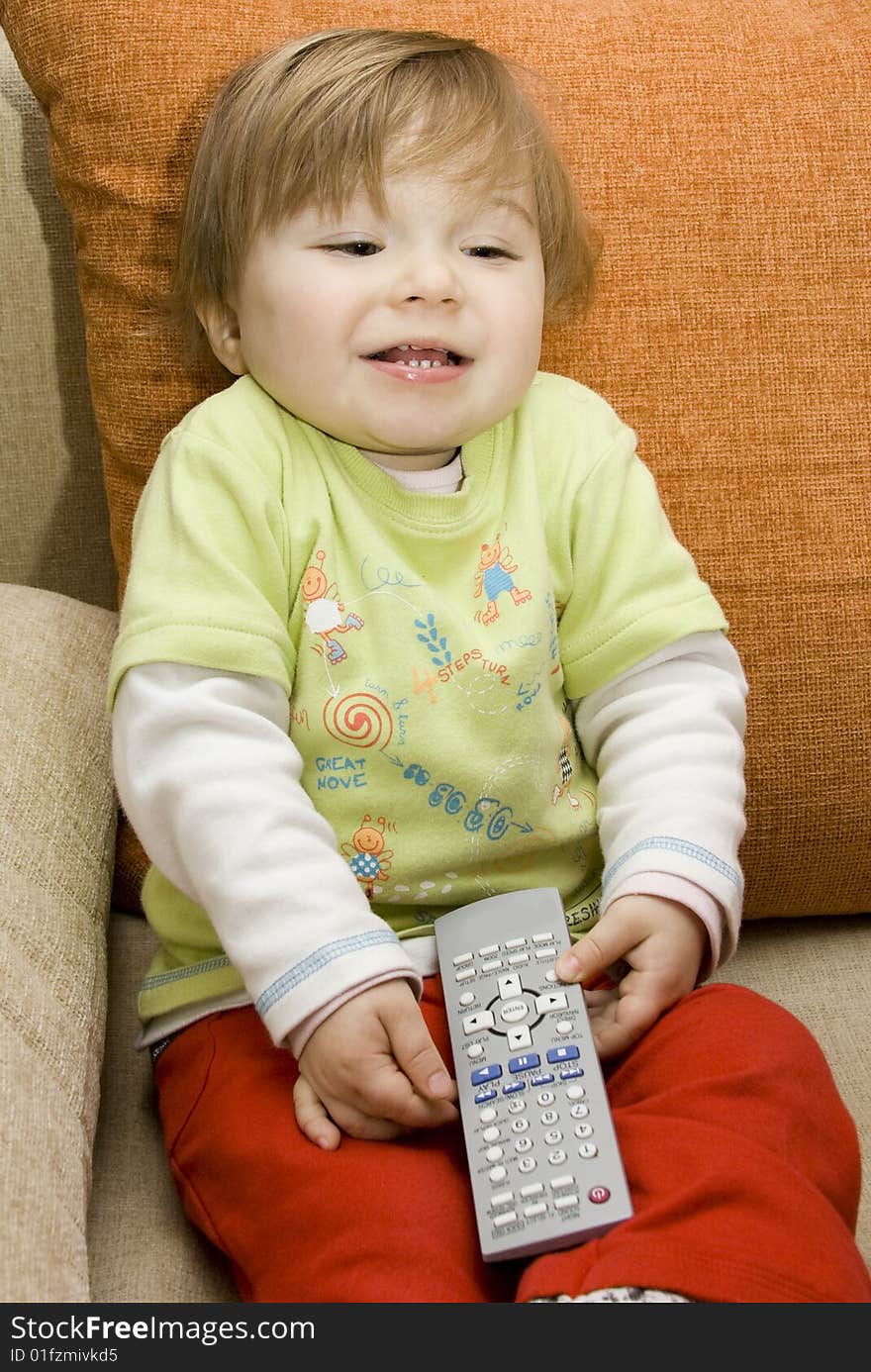 Baby girl with remote control on  sofa