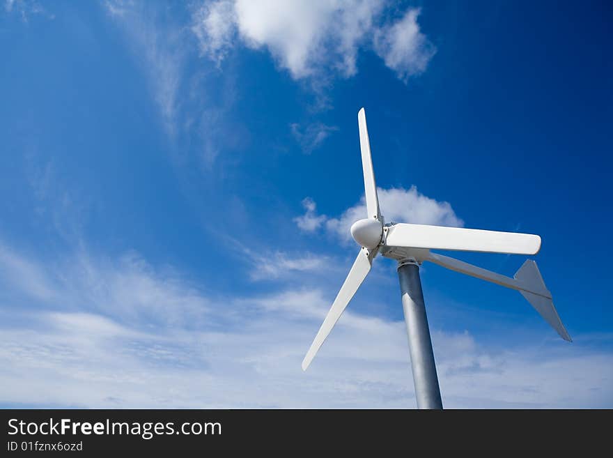 A wind turbine in a beautiful blue and cloud sky. A wind turbine in a beautiful blue and cloud sky