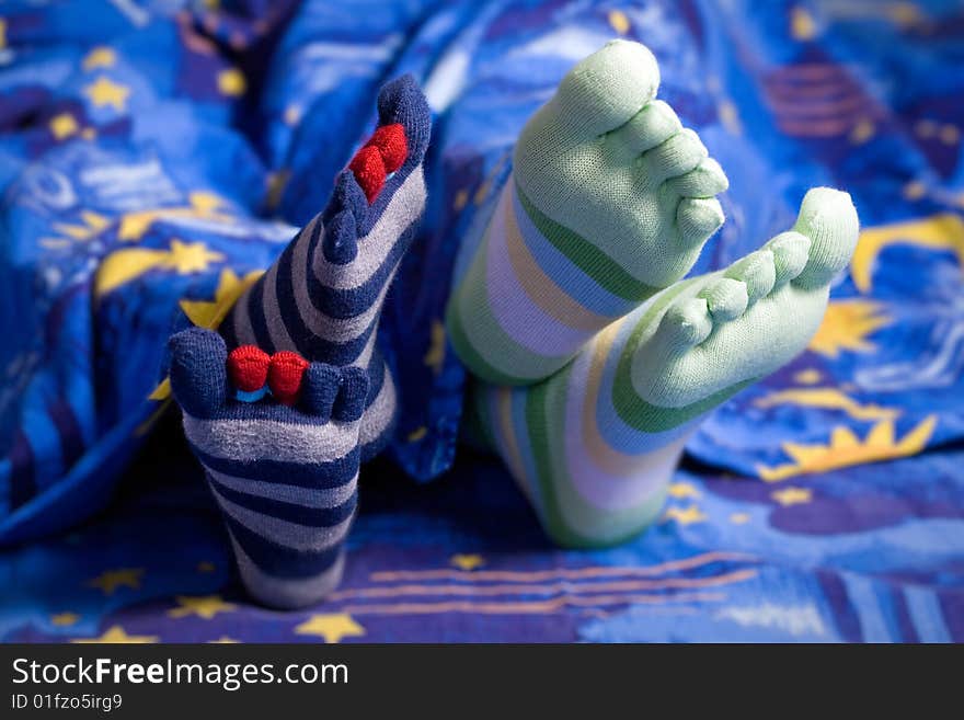 Stock photo: an image of two pairs of feet in striped socks. Stock photo: an image of two pairs of feet in striped socks