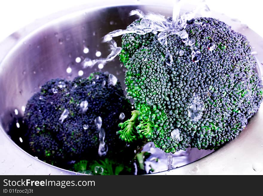 Fresh Broccoli splashed with water in colander. Fresh Broccoli splashed with water in colander