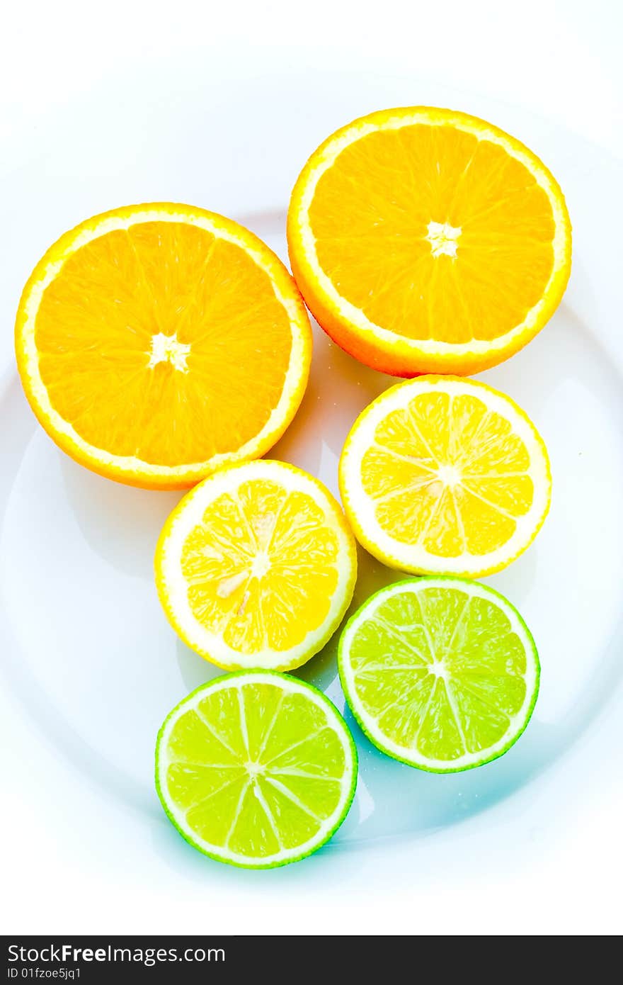 Arrangement of citrus fruits on plate on white. Arrangement of citrus fruits on plate on white